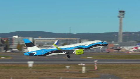 Oslo Airport Norway - September 27 2021: Air baltic airbus 220 airplane taking off special livery estonian flag panning right