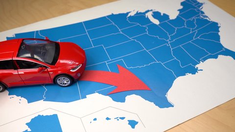 Barcelona, Spain. October 21: Red Tesla Model X toy car over a USA map moving from California to Texas