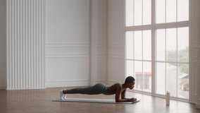 Athletic Young Black Woman Making Plank Exercise While Training At Home, Side View Shot Of Sporty African American Female Improving Endurance, Enjoying Domestic Workout, Slow Motion Footage