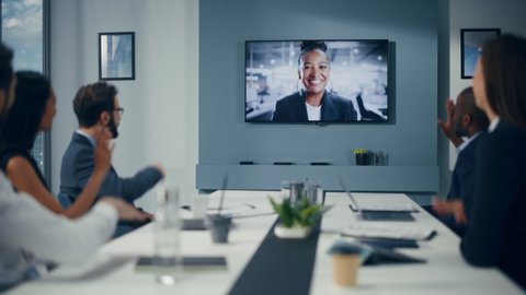Video Conference Call in Office Boardroom Meeting Room: Black Female Executive Director Talks with Group of Entrepreneurs, Managers, Investors. Businesspeople Discuss e-Commerce Investment Strategy