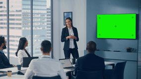 Office Conference Room Meeting Presentation: Young Motivated Caucasian Businesswoman Talks, Uses Green Screen Chroma Key Wall TV. Successfully Presenting a Product to Group of Multi-Ethnic Investors - Powered by Shutterstock - Get 15% off with code: PIKWIZARD15