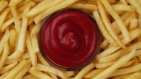 French fries and ketchup sauce top view, rotation. Fry potatoes. 4K UHD video 