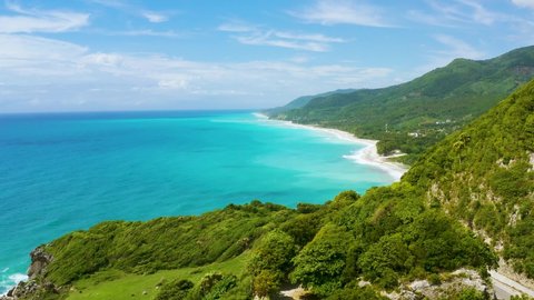 Beautiful tropical landscape in the Barahona mountains of the Dominican Republic. Aerial view of high green volcanic mountains in a blue Caribbean sea landscape. Mountains and sea of the Dominican.