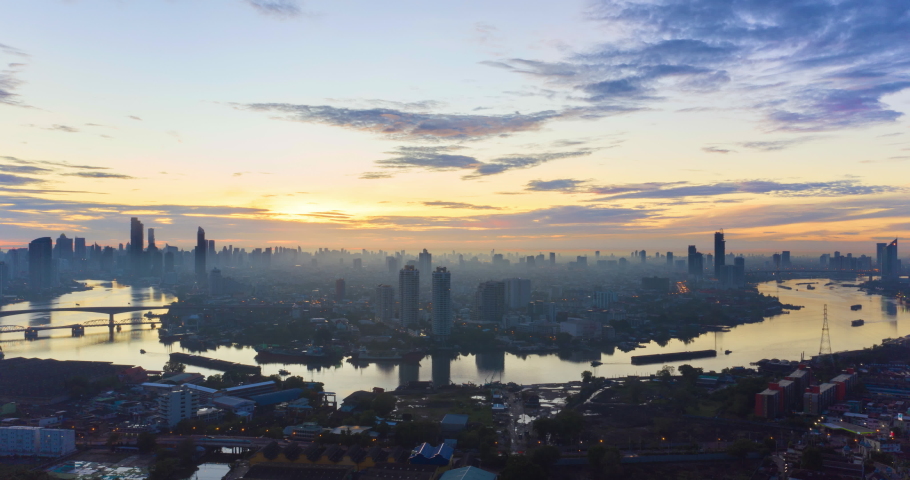 Hyperlapse aerial view landmark financial district and business center with skyscraper over Chao Phraya River at Bangkok, Thailand. Amazing sunrise drone footage over smart urban city skyline in 4K. Royalty-Free Stock Footage #1080394517