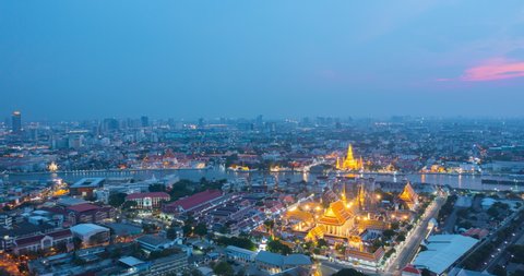 Aerial view Day to Night Time lapse of Chao Phraya River with Royal Grand Palace and Emerald Buddha Temple Landmark of Bangkok, Thailand. Amazing Drone Footage over the City skyline in twilight.