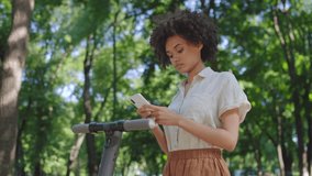 Busy woman stopping e-scooter ride to chat on smartphone, surfing rental app - Powered by Shutterstock - Get 15% off with code: PIKWIZARD15
