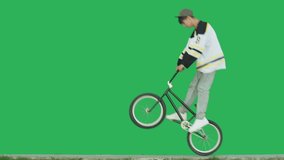 Extreme bmx guy biker wearing hockey jersey pedaling and jumping tricks over green screen background. Sporty young man rider have fun with bicycle. 4k raw video footage - Powered by Shutterstock - Get 15% off with code: PIKWIZARD15