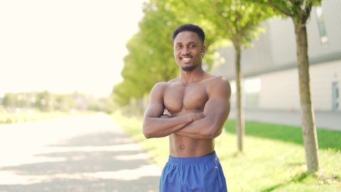 Portrait confident African American athlete standing urban background city park or stadium looking at camera  shirtless male strong fitness trainer coach man outdoors, muscular man outside