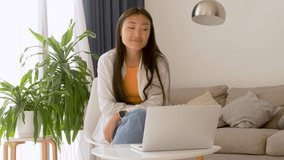 Beautiful young asian woman having videocall on laptop
