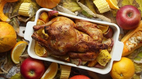 Festive chicken baked by Thanksgiving on white oven plate and a harvest of seasonal vegetables