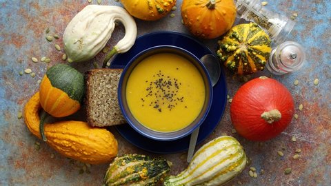 Compositon with autumn classic food. Tasty homemade pumpkin soup decorated with black seed
