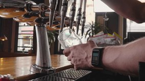 Slow Motion Macro Shot Of A Bartender In A Traditional London Pub Pouring A Fresh Golden Pint Of Lager Beer With A Head Of Foam And Moisture Rolling Down The Glass  - Powered by Shutterstock - Get 15% off with code: PIKWIZARD15
