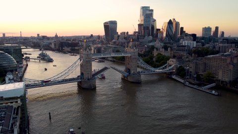 Aerial sunset view to the lifted Tower Bridge and skyline of the financial district City of London, Unuted Kingdom