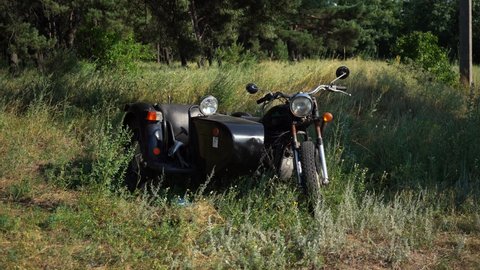 old soviet motorcycle stands in a field on the grass