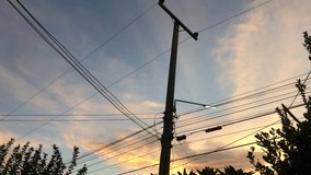 Electric pole with orange sunset background, 4K video clip