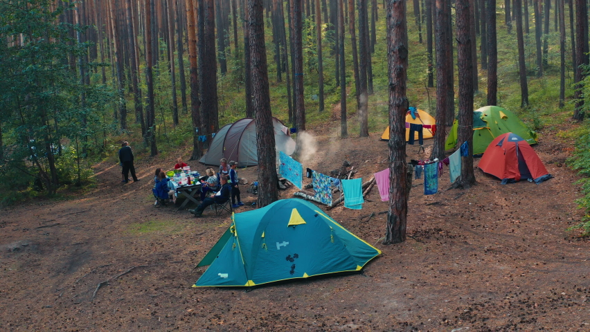 Family camping aerial. Aerial view of the extended family enjoying camping in the dry forest with pine trees Royalty-Free Stock Footage #1080446660