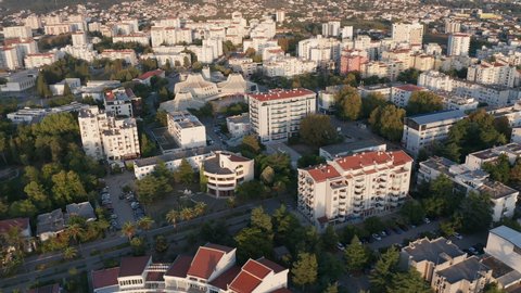 Bar Montenegro - Aerial drone view of white multistory apartment buildings among trees in residential district of city downtown planned with green urbanism in mind, on sunny morning or afternoon.