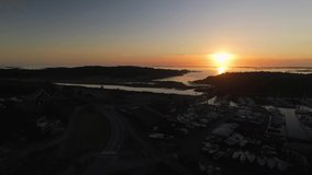 Aerial view of a beautiful sunset over the sea behind the island Amundon in Gothenburg in autumn. 4k drone footage.