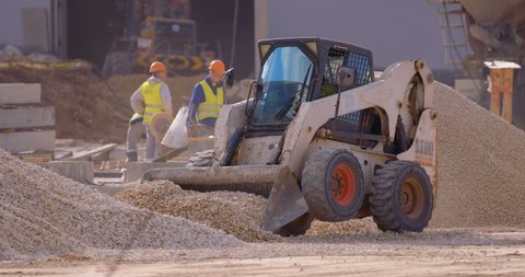 Excavation at a construction site, mini loader bobcat transports crushed stone to different construction places, where it is advisable to use compact construction equipment