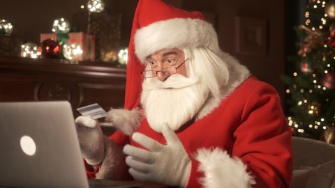 Happy Santa Claus shopping online with credit card. Online banking with smart phone. Lifestyle. Easy pay using smart phone or digital device. Communication via app for sale in shop. Modern technology
