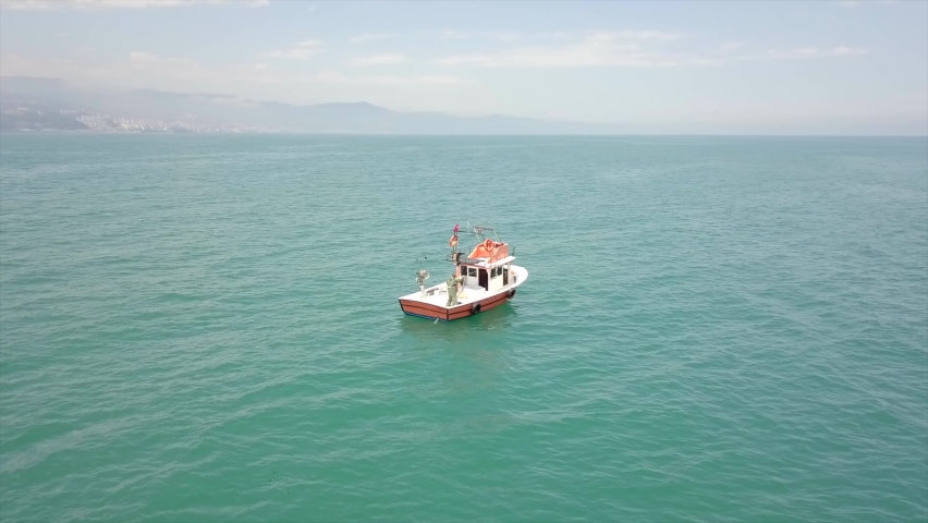 A beautiful day at the Black Sea.A small fishing boat and a fisherman are fishing.