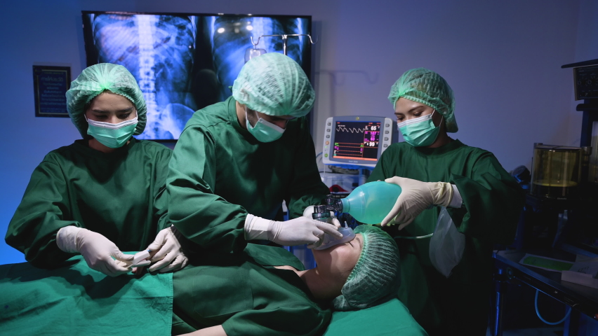 Professional surgeon doctor and team in uniform give anesthesia and IV saline drip with examining fingertip pulse of young woman treatment patient before plastic surgery in operating room at hospital. Royalty-Free Stock Footage #1080468761