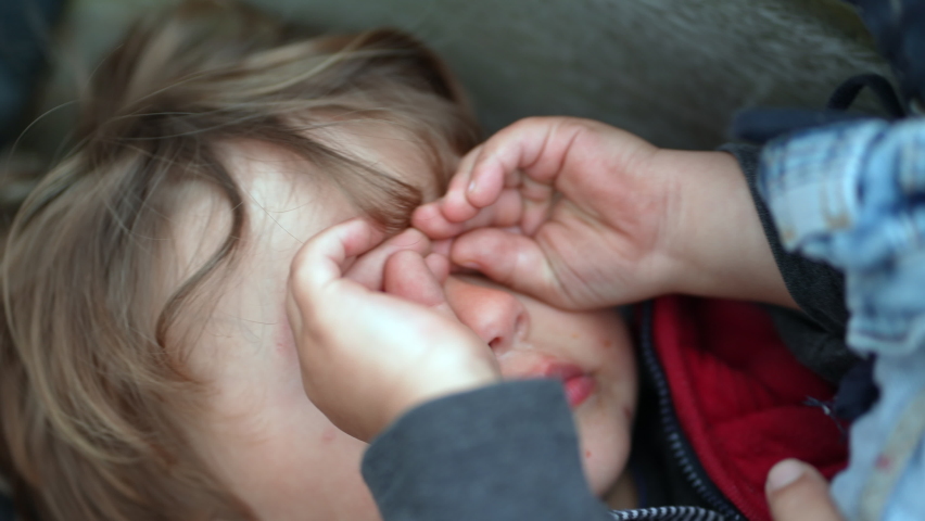 Tired child rubbing eyes with hand. Exhausted sleepy kid rubs eye with hands Royalty-Free Stock Footage #1080471137