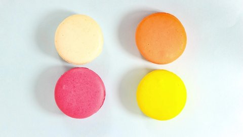 Animation of a traffic stop. Several colored macarons with move on a light surface. Top view.