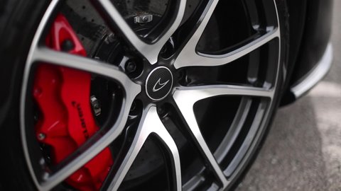 United Kingdom, Manchester October 2021. The Carbon Fibre McLaren Speedmark Badge On The Front Diamond Cut Alloy Wheel Of A Black 2016 McLaren 570S With Red Brake Callipers