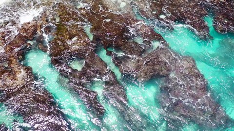 Beautiful rocks in turquoise water. waves rolled on shore stone, broken and hissing