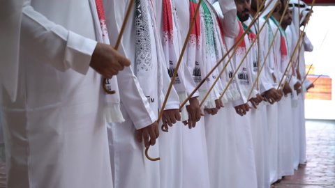 arabs in traditional dress dancing a traditional dance on national day outlet village dubai UAE 2019.02.12