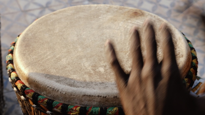A Senegalese man plays a traditional djembe drum. West-african traditional music, often played in the streets and on festivals. | Shutterstock HD Video #1080489332