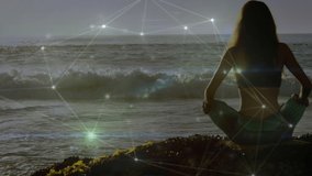 Animation of networks of connections over caucasian woman praciticing yoga on beach. global sports, fintess and healthy lifestyle concept digitally generated video.