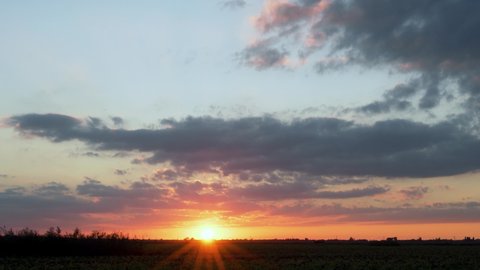 Beautiful Lapse Time of the Sunset of the Sky Clouds of the Sun over the Horizon in the Field in Autumn. The Shining Sun Sets over the Horizon at Sunset, Colorful Sky. 4k Timelapse, View, Landscape.