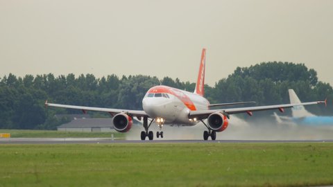 AMSTERDAM, THE NETHERLANDS - JULY 25, 2017: Airbus A320 EasyJet picks up speed and takes off at Schiphol International Airport, Amsterdam (AMS). Airplane taking off, close-up