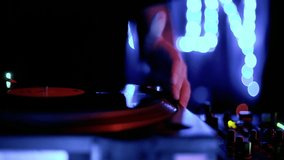 Techno dj playing music in nightclub. Disc jockey mixing vinyl records on a party