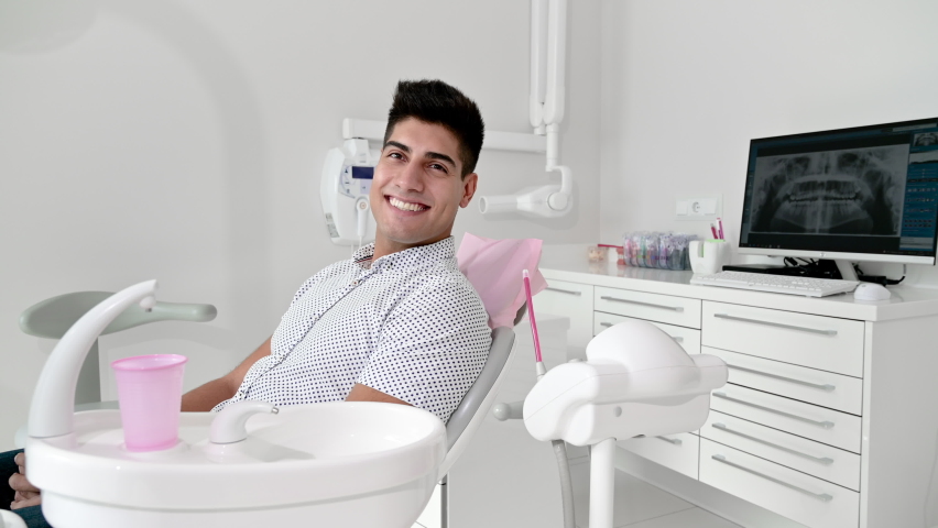 Portrait of happy smiling young hispanic man looking at camera after visiting dentist. High quality 4k footage