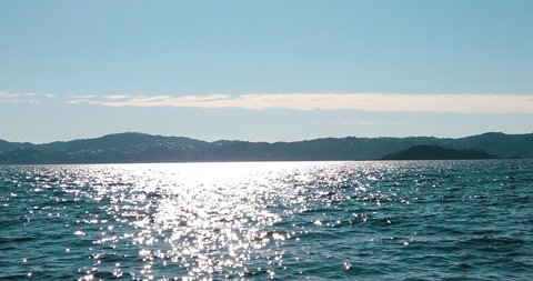 Slow motion - Dazzling harbour waves, mid-Summer view to Wellington - New Zealand
