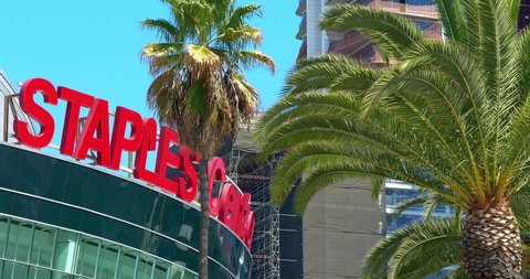 LOS ANGELES, CALIFORNIA, USA - OCTOBER 3, 2021: Palm trees and Staples Center Sign near L.A. LIVE entertainment complex in Los Angeles Downtown, California, 4K
