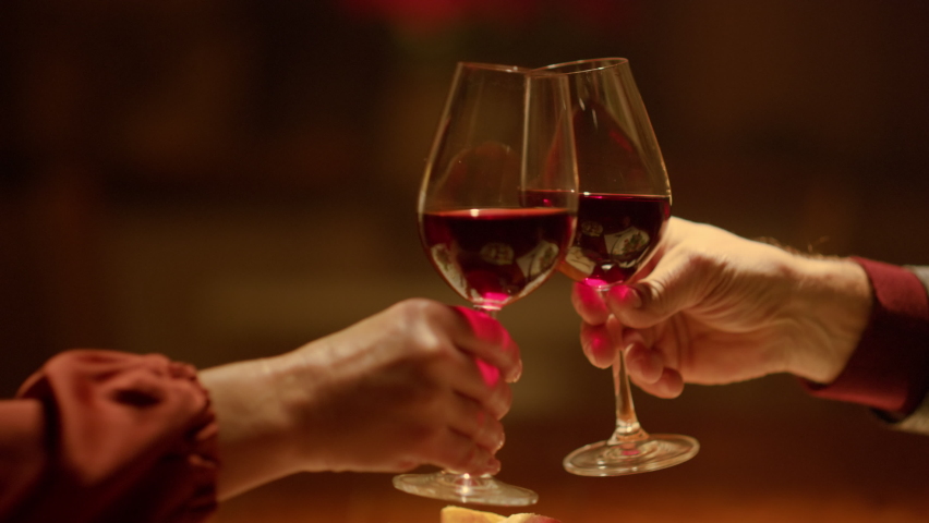 Closeup clinking wine glasses in senior couple hands. Grandparents toasting wine glasses in restaurant. Mature couple date home. Rich old people enjoy retirement time. Old aged couple romantic dinner  Royalty-Free Stock Footage #1080535157