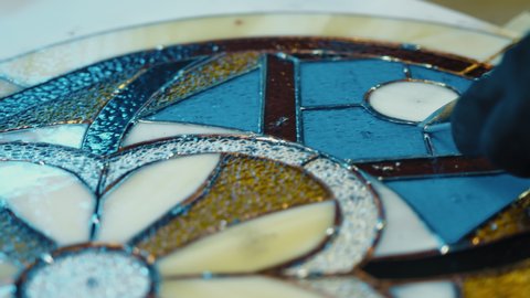 Close-up Soldering of stained glass seams. Stained glass workshop, needlework. Handicraft, creativity. Tiffany stained glass 
