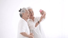 Senior women looking at smartphone screens with a smile