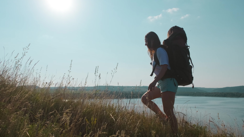 The young woman hiking with backpack along the beautiful coast. slow motion