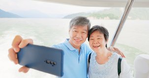 Authentic shot of asian elderly couple have video chat by mobile phone happily on boat in close up