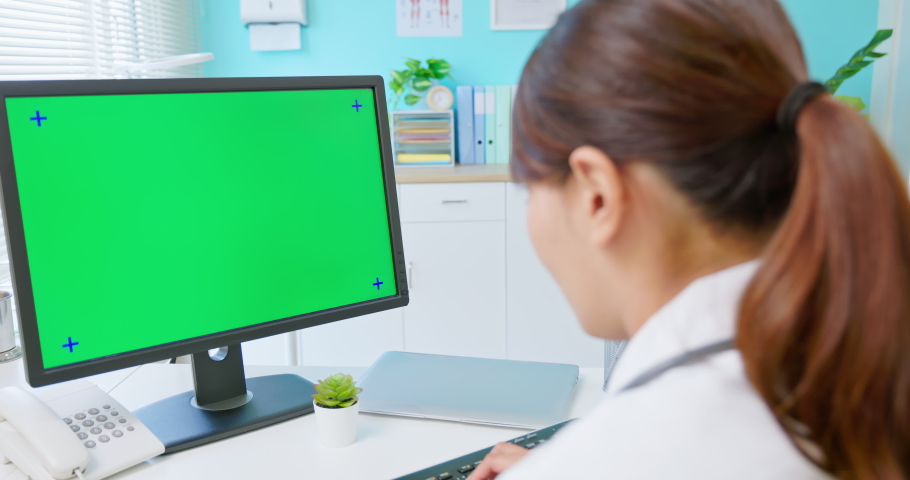 back view of asian female doctor works and uses computer with green screen monitor in hospital Royalty-Free Stock Footage #1080547457