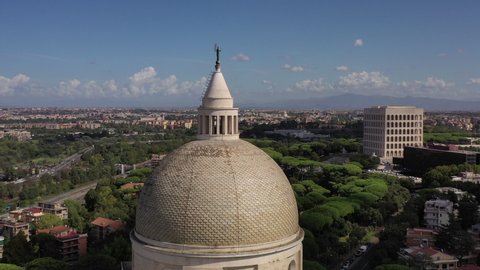 The basilica of Saints Peter and Paul in the Eur district of Rome.
Spectacular aerial shot with drone around the dome with a view over the whole Eur district