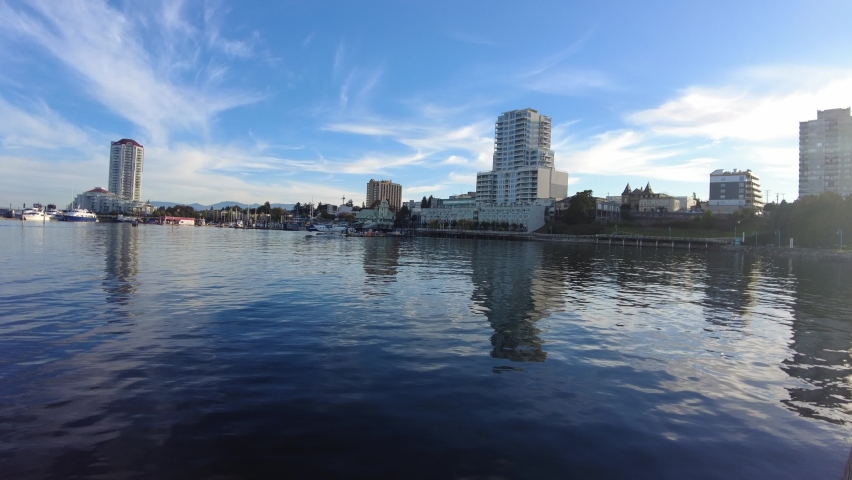 Nanaimo waterfront with boats in a distance. Buildings overlook the harbor and marina in Downtown Nanaimo, British Columbia, Canada.