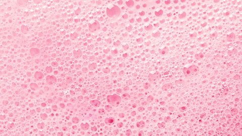 Texture of pink soap foam with bubbles abstract background. Cosmetic for body and shower.