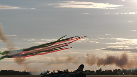 Rivolto Italy SEPTEMBER, 17, 2021 Aermacchi MB-339 A PAN of Frecce Tricolori. Tracking view group of jets fly dangerously performing stunt leaving red green contrails smoke in the sky on air- show