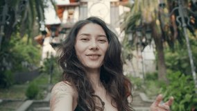 Young smiling hipster asian woman in summer clothes. Girls taking selfie self portrait photos on smartphone. Model posing on street background. Female showing positive face emotions